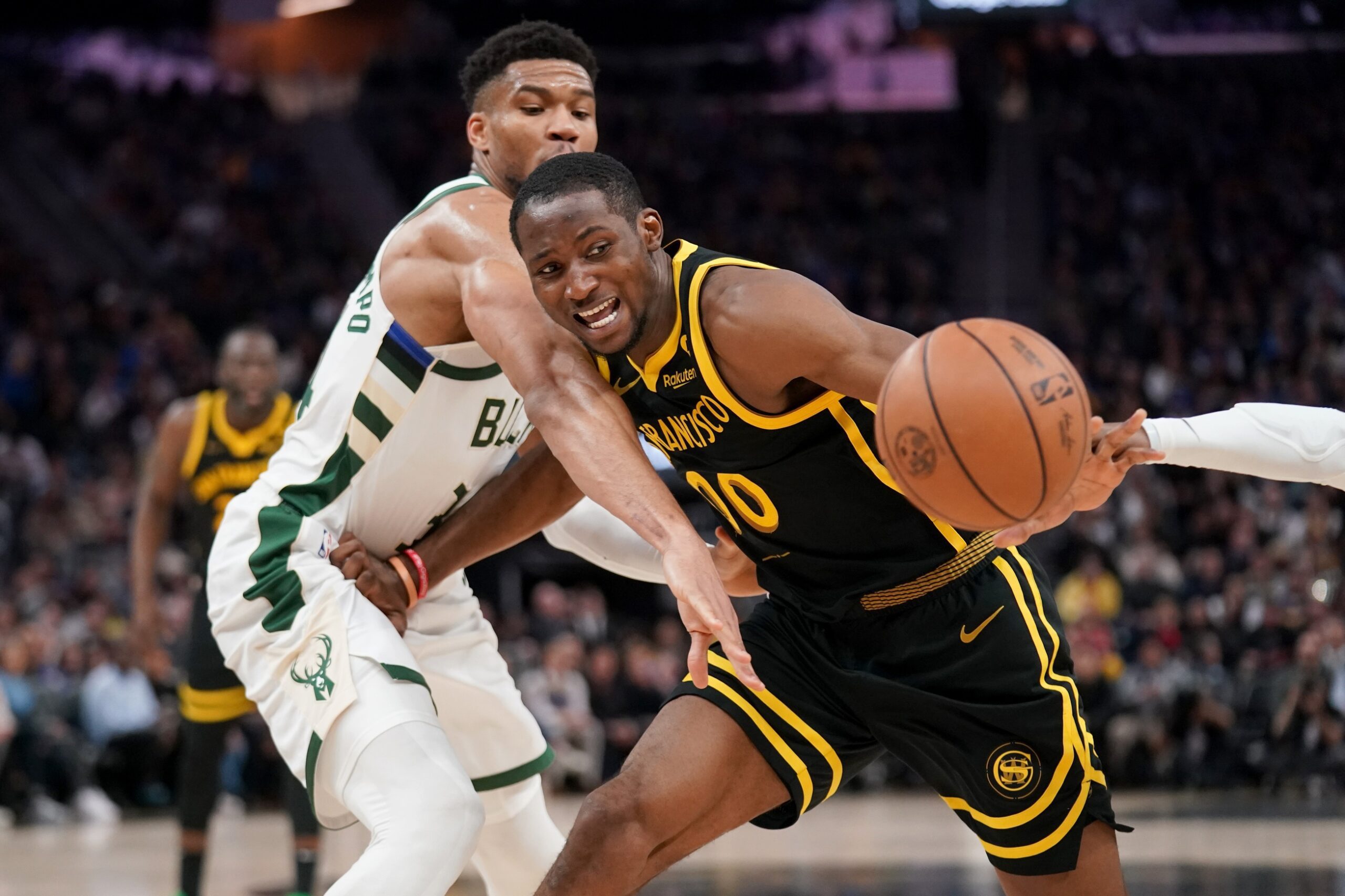 Mar 6, 2024; San Francisco, California, USA; Golden State Warriors forward Jonathan Kuminga (00) loses control of the ball next to Milwaukee Bucks forward Giannis Antetokounmpo (34) in the third quarter at the Chase Center. Mandatory Credit: Cary Edmondson-USA TODAY Sports