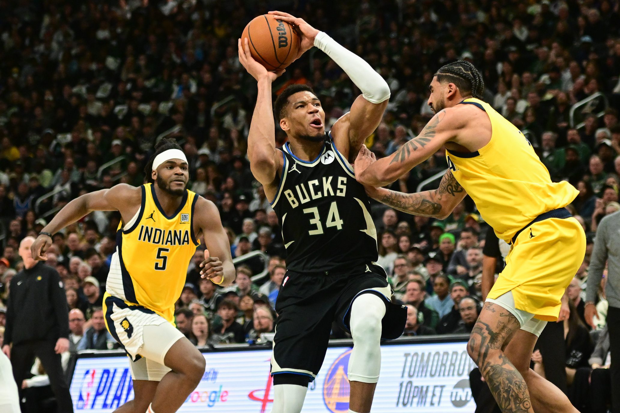 Apr 27, 2025; Milwaukee, Wisconsin, USA; Milwaukee Bucks forward Giannis Antetokounmpo (34) takes a shot against Indiana Pacers forward Obi Toppin (1) and forward Jarace Walker (5) in the third quarter during game four of first round for the 2024 NBA Playoffs at Fiserv Forum. Mandatory Credit: Benny Sieu-Imagn Images