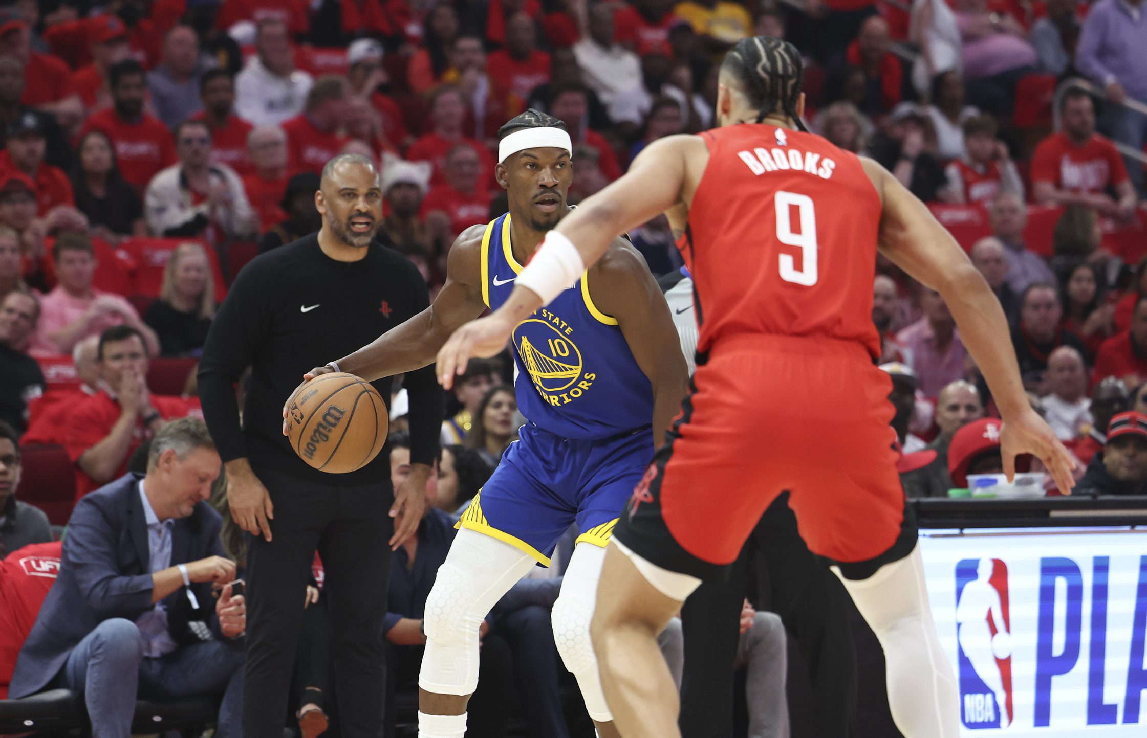 Golden State Warriors forward Jimmy Butler III (10) controls the ball as Houston Rockets forward Dillon Brooks (9) defends during the first quarter at Toyota Center.