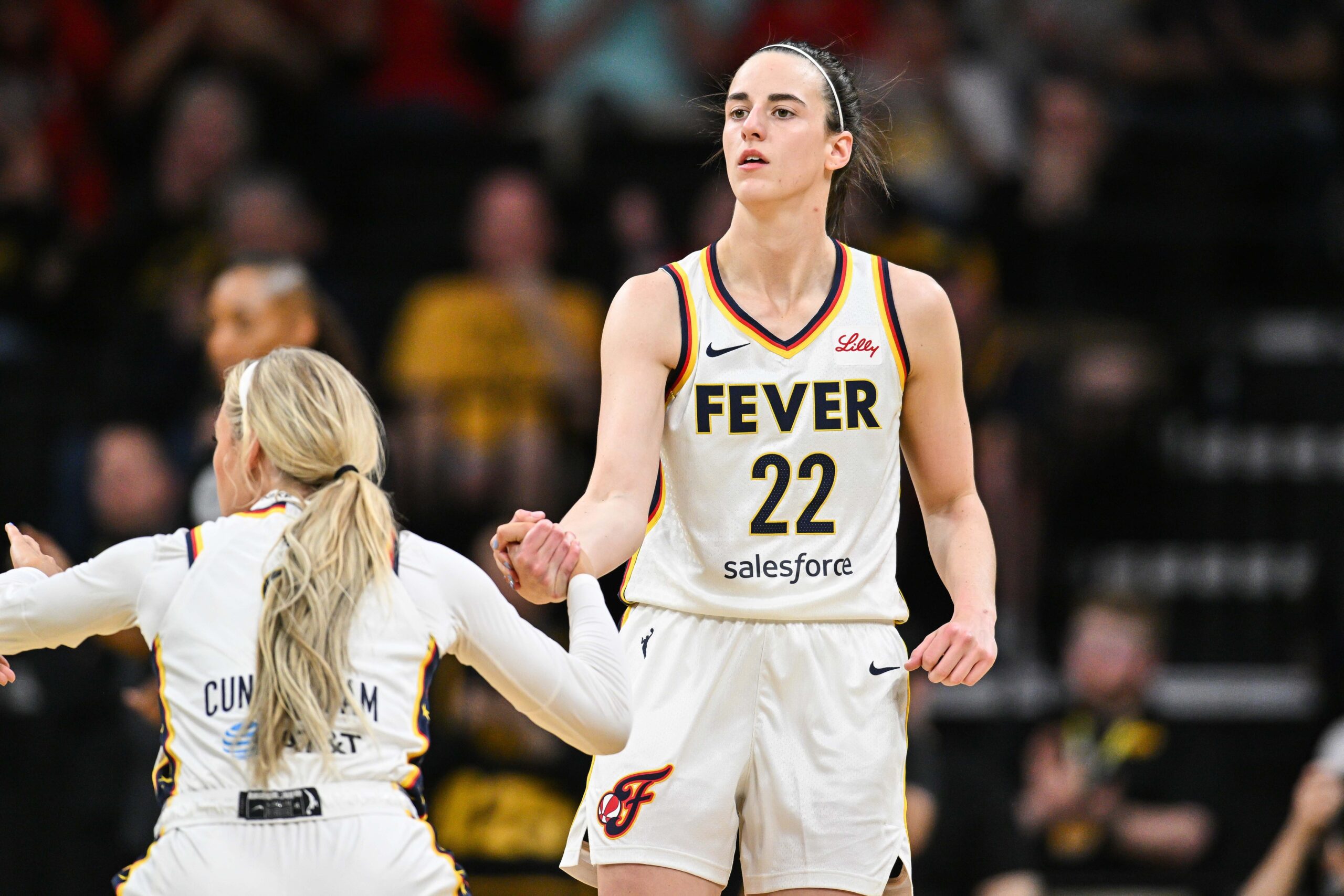 May 4, 2025; Iowa City, IA, USA; Indiana Fever guard Caitlin Clark (22) assists guard Sophie Cunningham (8) during the game against the Brazil National Team at Carver-Haweye Arena. Mandatory Credit: Jeffrey Becker-Imagn Images