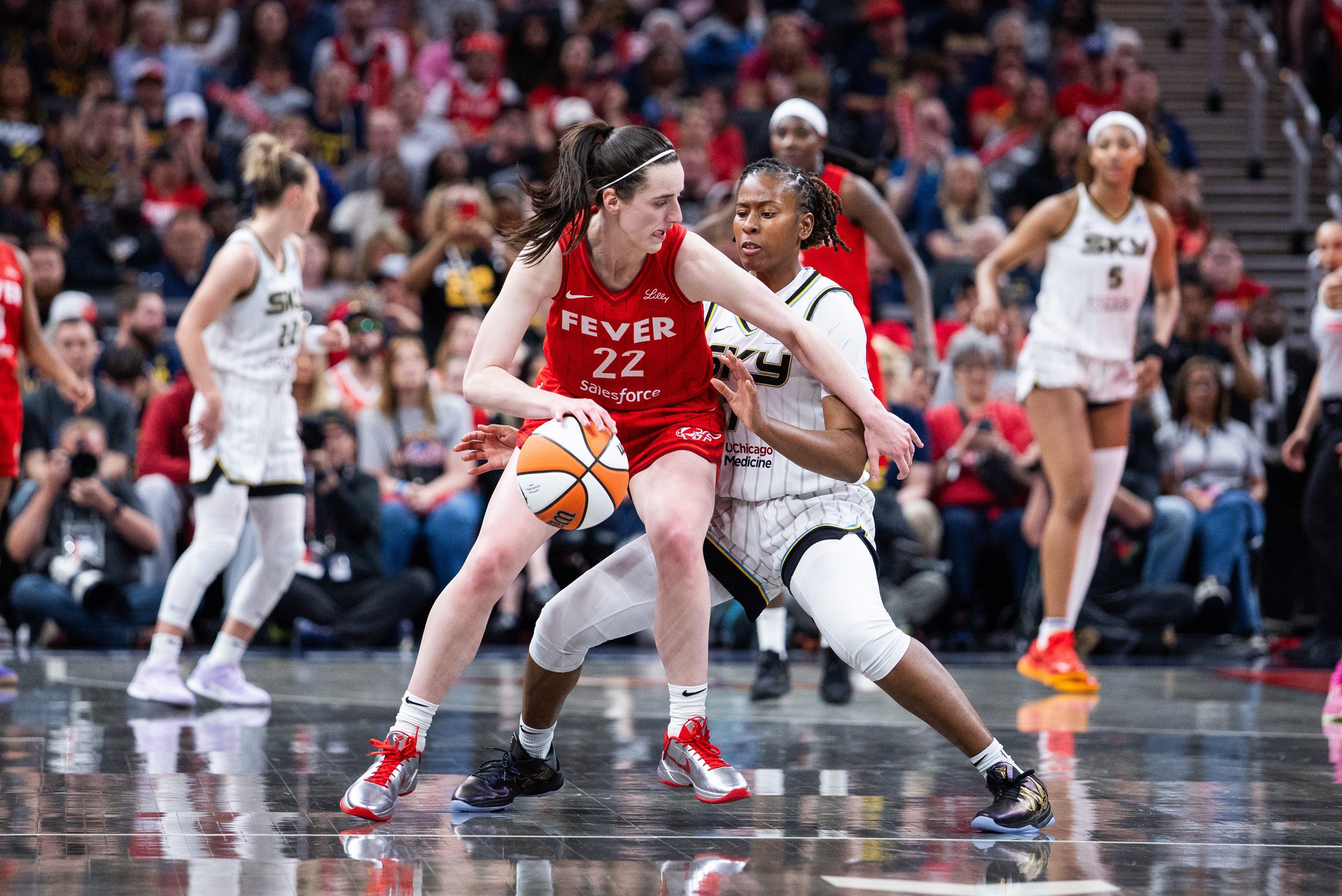 May 17, 2025; Indianapolis, Indiana, USA; Indiana Fever guard Caitlin Clark (22) dribbles the ball while Chicago Sky guard Ariel Atkins (7) defends in the second half at Gainbridge Fieldhouse. Mandatory Credit: Trevor Ruszkowski-Imagn Images