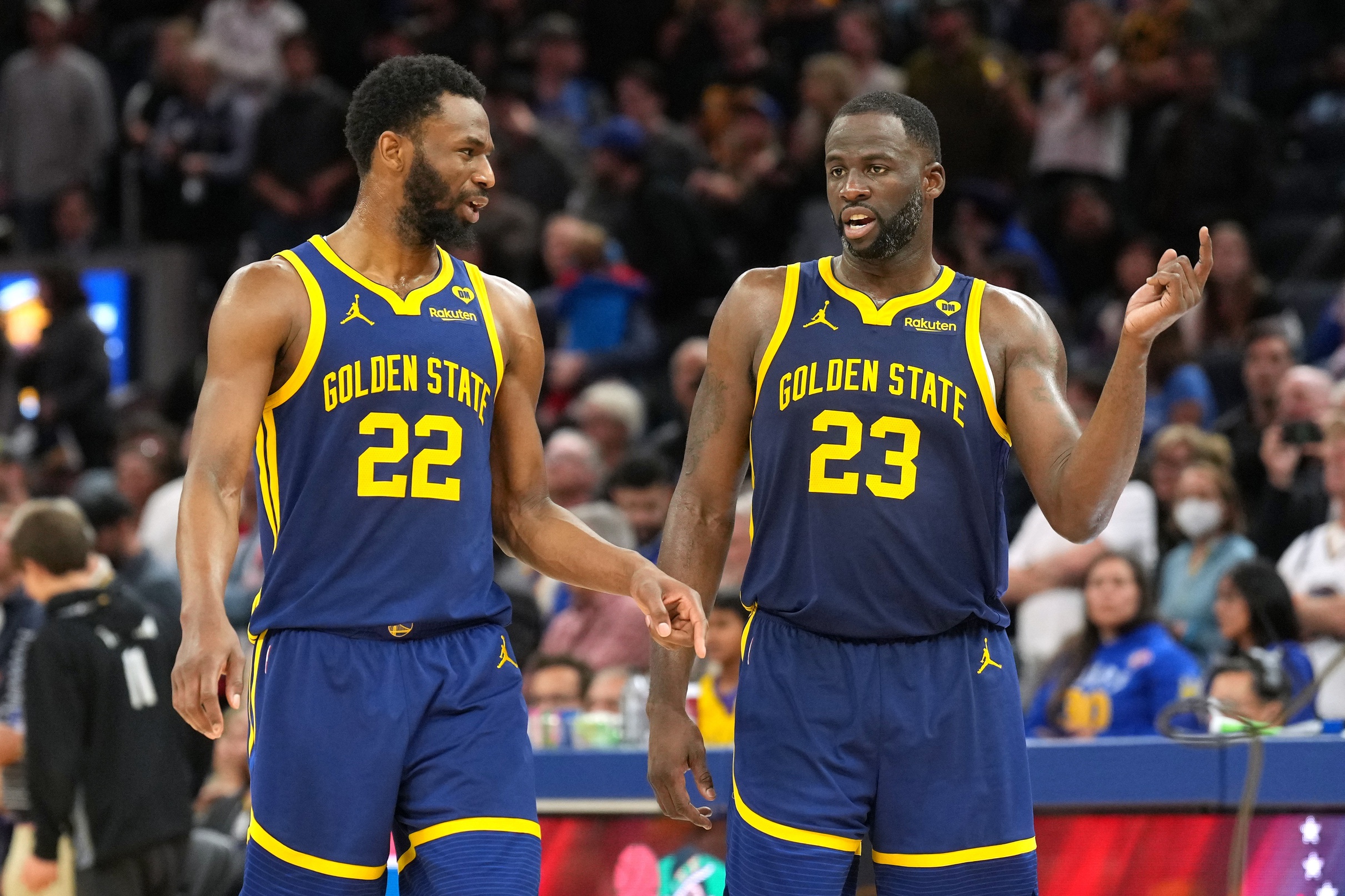 Jan 27, 2024; San Francisco, California, USA; Golden State Warriors forwards Andrew Wiggins (22) and Draymond Green (23) talk during overtime against the Los Angeles Lakers at Chase Center. Mandatory Credit: Darren Yamashita-USA TODAY Sports
