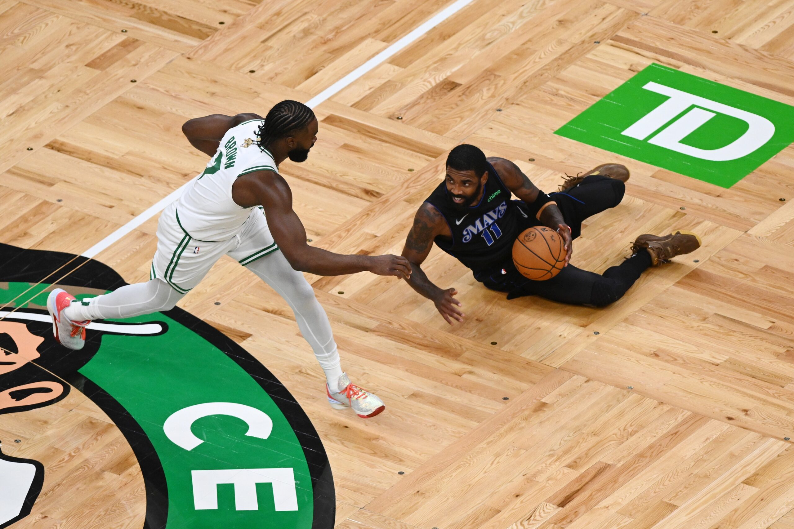 Jun 6, 2024; Boston, Massachusetts, USA; Dallas Mavericks guard Kyrie Irving (11) falls while defended by Boston Celtics guard Jaylen Brown (7) during the first quarter of game one of the 2024 NBA Finals at TD Garden. Mandatory Credit: Peter Casey-USA TODAY Sports