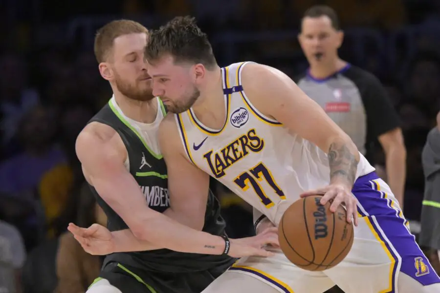 Minnesota Timberwolves guard Donte DiVincenzo (0) reaches in on Los Angeles Lakers guard Luka Doncic (77) in the second half at Crypto.com Arena.